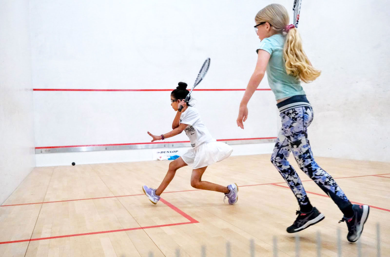 Two girls playing squash at the English Junior Championships 2023